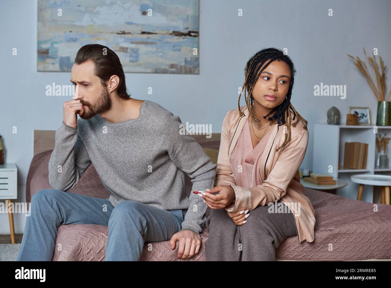 abortion concept, man and african american woman with pregnancy test, stressed couple, tense Stock Photo