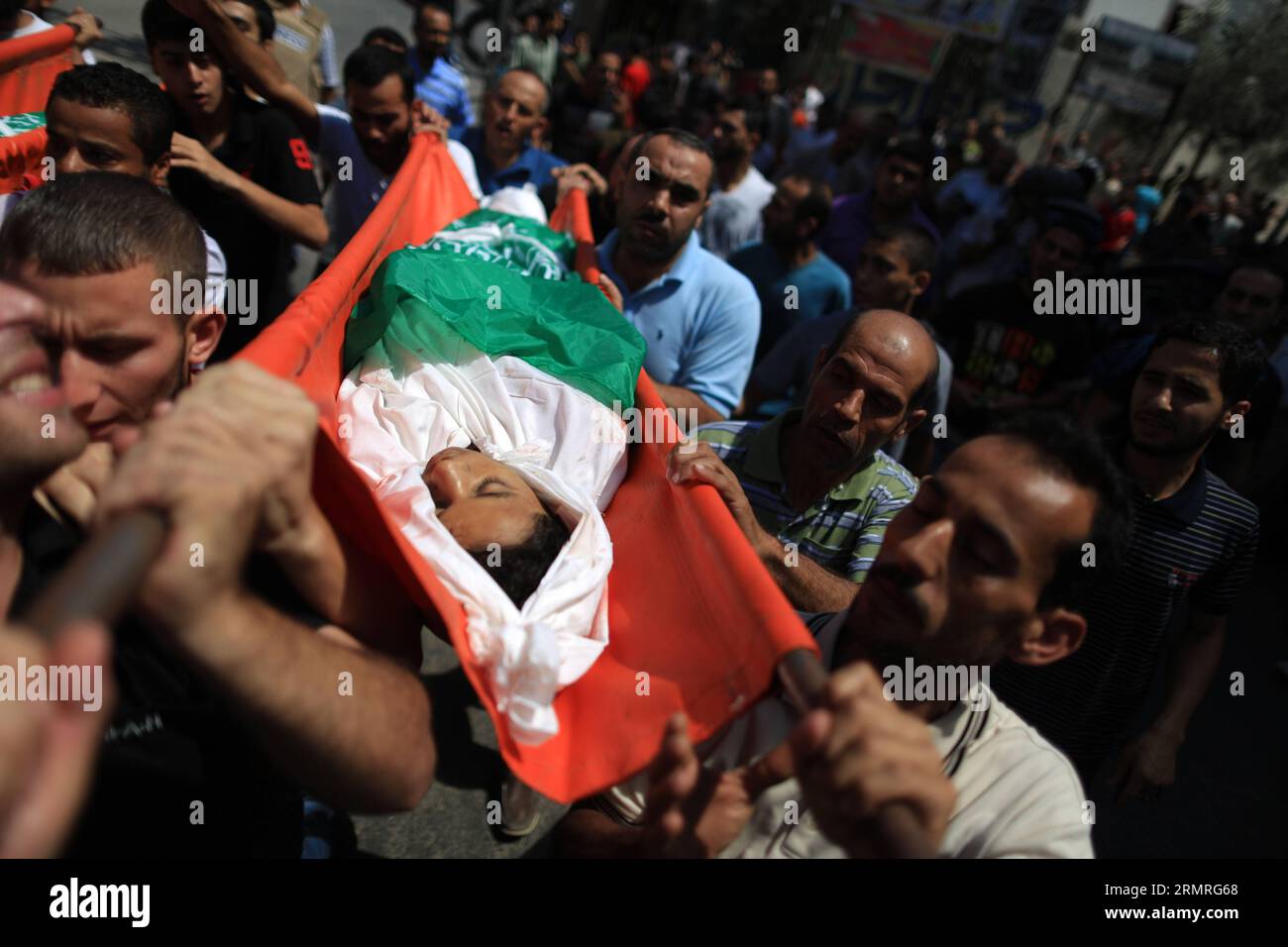 GAZA, July 18, 2014 (Xinhua) -- People carry the body of Walaa Abu Musallam, a Palestinian girl who was killed along with her two brothers in an Israeli tank attack, during their funeral in northern Gaza strip town of Beit Lahia, on July 18, 2014. (Xinhua/Wissam Nassar)(zhf) MIDEAST-GAZA-FUNERAL PUBLICATIONxNOTxINxCHN   Gaza July 18 2014 XINHUA Celebrities Carry The Body of  Abu Musallam a PALESTINIAN Girl Who what KILLED Along With her Two Brothers in to Israeli Tank Attack during their Funeral in Northern Gaza Strip Town of Beit Lahia ON July 18 2014 XINHUA Wissam Nassar  Mideast Gaza Funera Stock Photo
