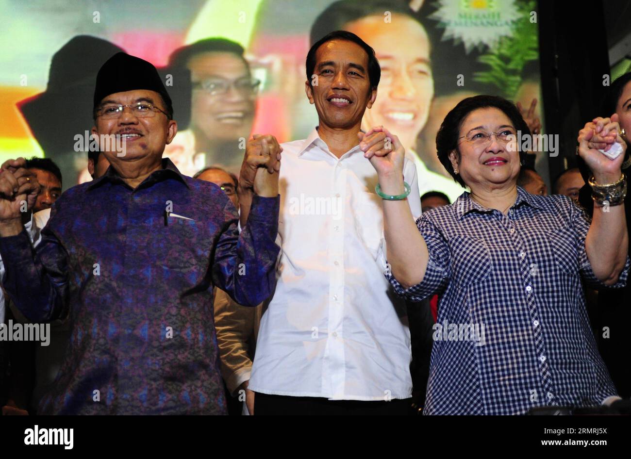 (140722) -- JAKARTA, July 22, 2014 (Xinhua) -- Chairperson of the Indonesian Democratic Party of Struggle (PDIP) Megawati Soekarnoputri (R), Indonesia s presidential candidate from the PDIP Joko Widodo (C) and his running mate Jusuf Kalla (L) hold hands during a press conference ahead of announcement of recapitulation 2014 presidential election in Jakarta, Indonesia, July 22, 2014. The General Election Commission (KPU) is scheduled to release the vote tally results this afternoon, qualifying the winner of election. (Xinhua/Zulkarnain) (lmz) INDONESIA-JAKARTA-PRESIDENT ELECTION-JOKO WIDODO PUBL Stock Photo