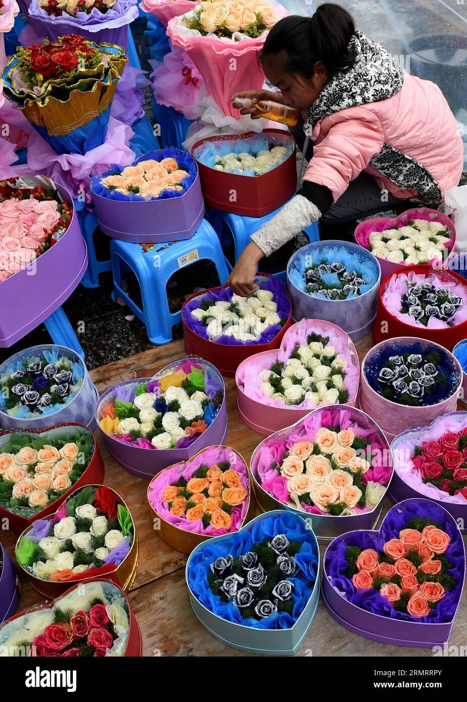 A vender arranges flowers ahead of the Qixi Festival in Dali city, southwest China s Yunnan Province, Aug. 1, 2014. The Qixi Festival, also known as Chinese Valentine s day, which falls on Aug. 2 this year, originates from a folk tale about a fairy falling in love with a mortal. The marriage allegedly enraged the Goddess of Heaven, who created the Milky Way to separate them. Supposedly, the pair of lovers are reunited for a single night each year by magpies that fly into the heavens and form a bridge for them to cross. ) (yxb) CHINA-QIXI-CHINESE VALENTINE S DAY-ACTIVITY (CN) LinxYiguang PUBLIC Stock Photo