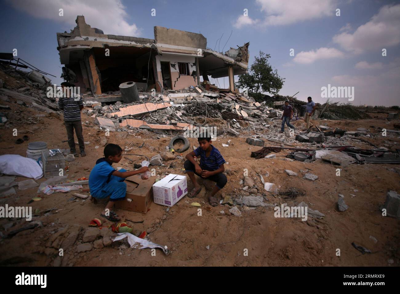 (140805) -- GAZA, Aug. 5, 2014 -- Palestinians collect belongings from their destroyed house after it was hit by an Israeli strike, in Khuzaa village, east of Khan Younis, in the southern Gaza Strip, on Aug. 5, 2014. A 72-hour ceasefire in the Gaza Strip brokered by Egypt came into effect at 8:00 a.m. local time (0500 GMT) on Tuesday, marking the latest attempt to stop the Israeli-Palestinian clashes after previous efforts ended in failure. ) MIDEAST-GAZA-CEASEFIRE YasserxQudih PUBLICATIONxNOTxINxCHN   Gaza Aug 5 2014 PALESTINIANS Collect belonging from their destroyed House After IT what Hit Stock Photo