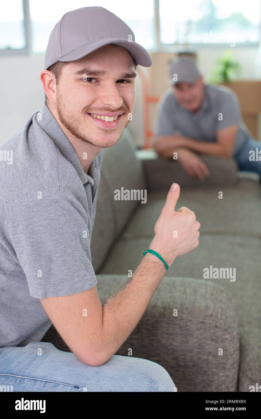 young handsome smiling mover wearing uniform Stock Photo