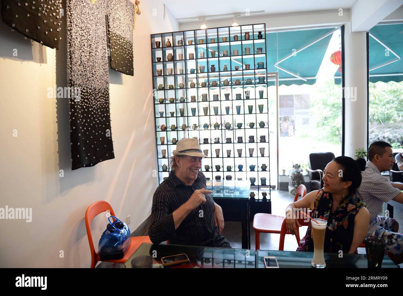 (140806) -- BEIJING, Aug. 6, 2014 -- Zhang Lingyun meets a British ceramic artist at a cafe in Jingdezhen, east China s Jiangxi Province, July 17, 2014. Zhang Lingyun is 40. It s been 20 years since the ceramic artist came to Jingdezhen, China s porcelain capital . Zhang s story with ceramics had a random, romantic start: she knew barely anything about ceramics before she came across the name Jingdezhen Ceramic Institute (JCI) when applying for college. Ceramics sounded interesting so I filed the application for JCI. The whim of impulse had made great difference in Zhang s life. Her very first Stock Photo
