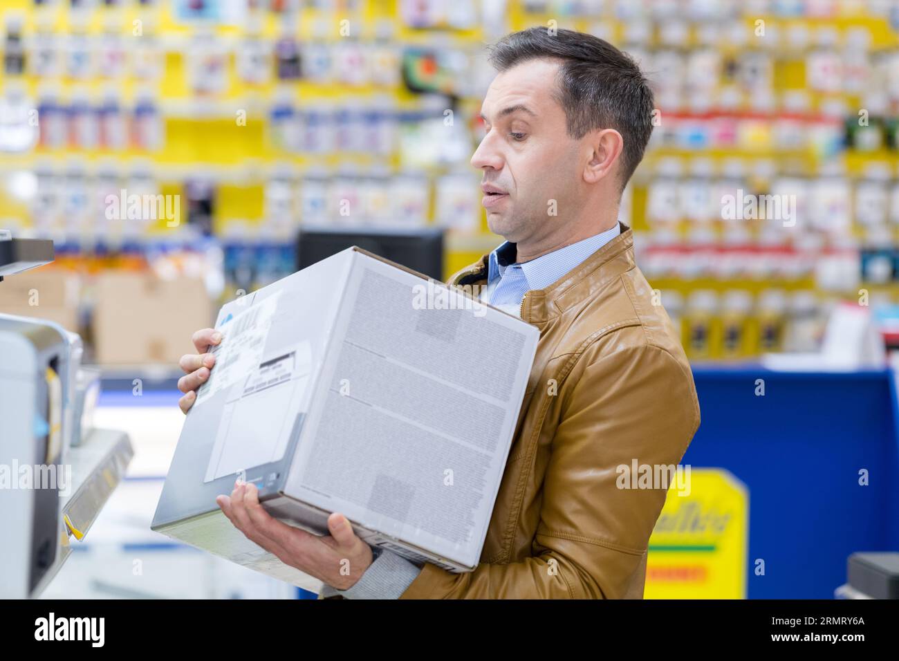 man holding big unpacked tv at tv shop Stock Photo