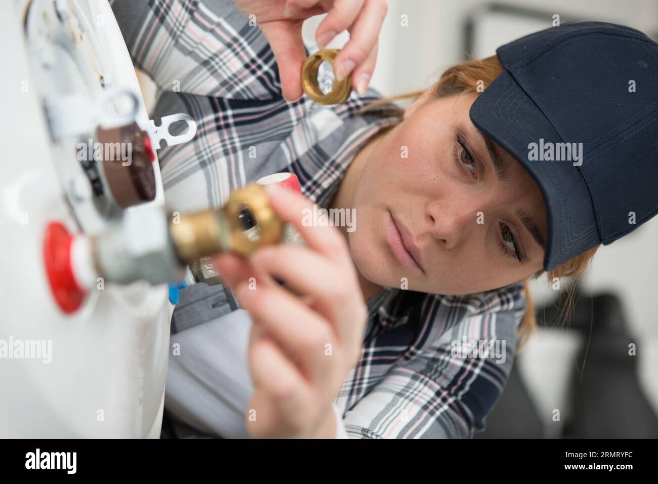 female technician servicing a boiler using tablet computer Stock Photo