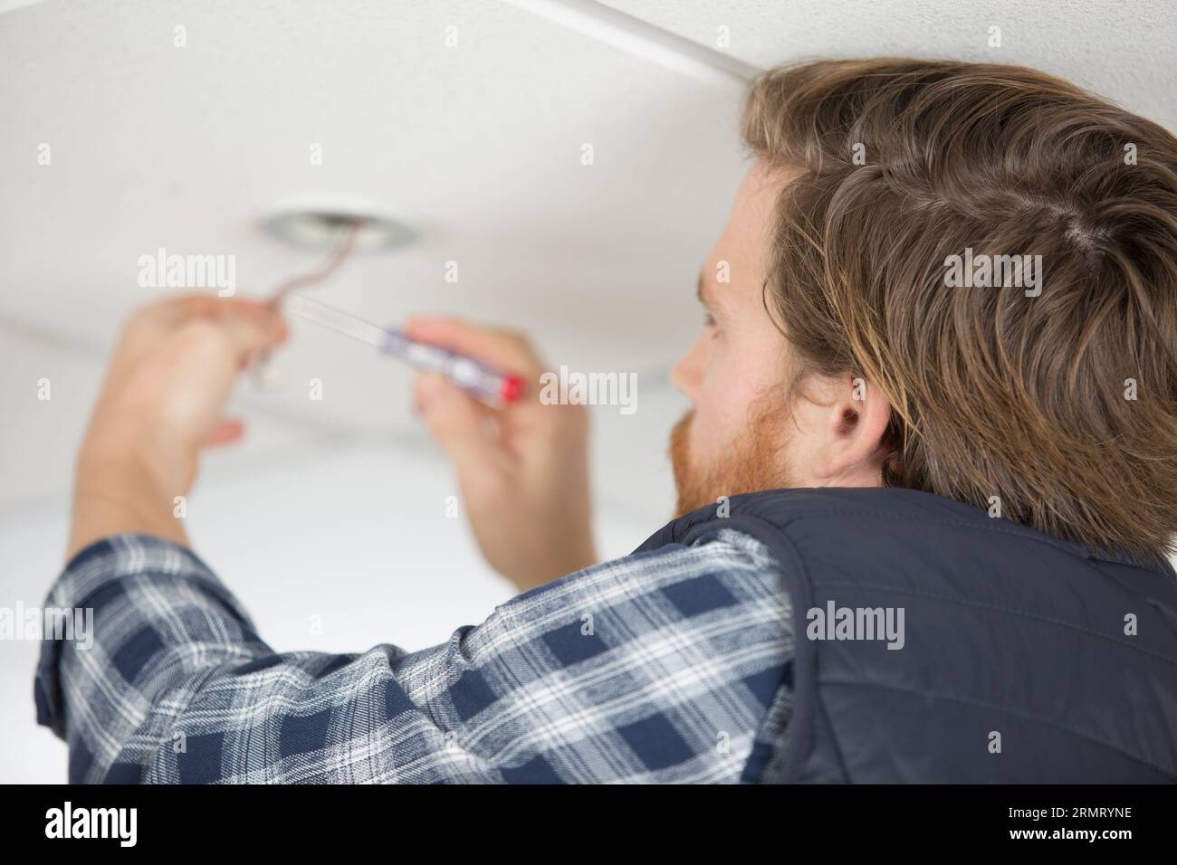 man testing cable with an electrical screwdriver Stock Photo