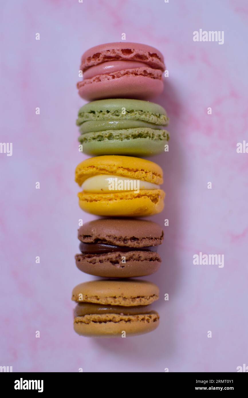 Colorful macarons stacked on pink marble Stock Photo