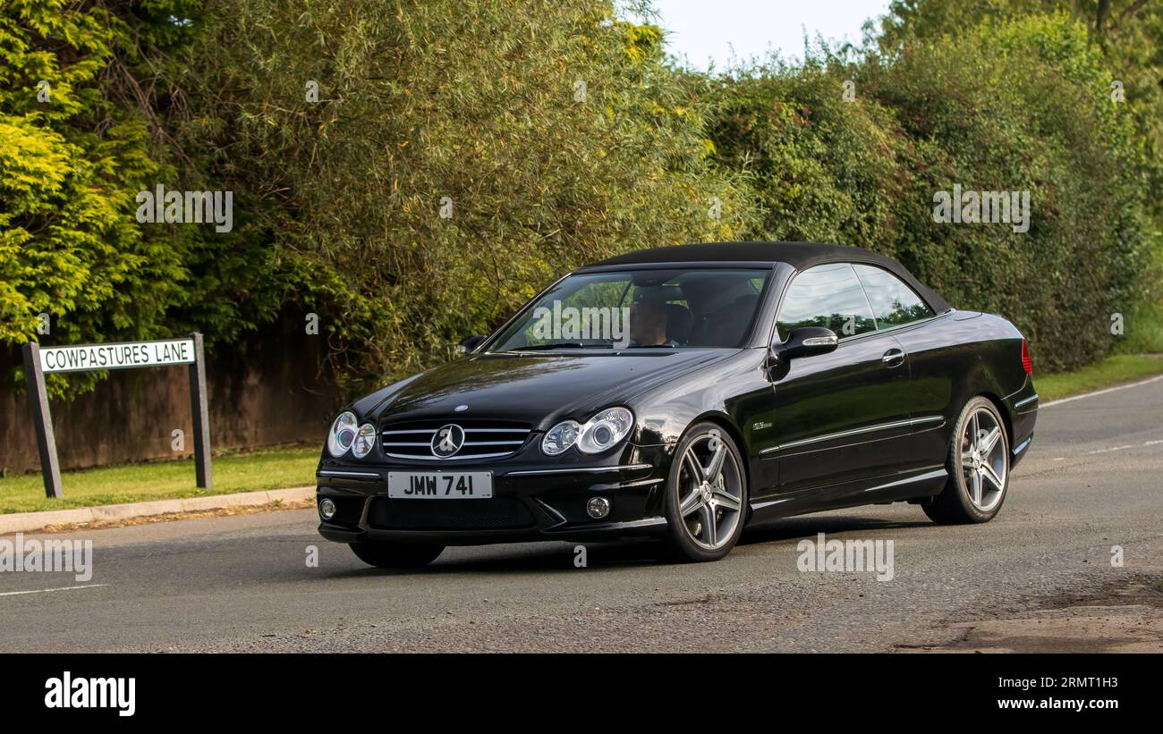 Whittlebury,Northants,UK -Aug 27th 2023:  2007 black Mercedes Benz CLK 63 AMG  car travelling on an English country road Stock Photo