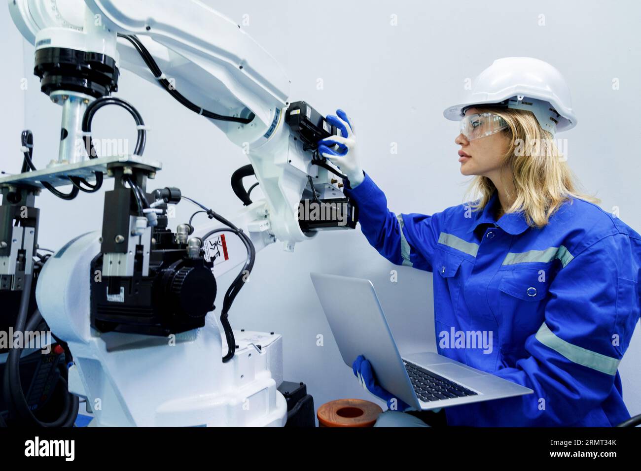 female automation machine engineer student study and inspection control robot arm machine in university or factory workshop. ai robot technology new i Stock Photo