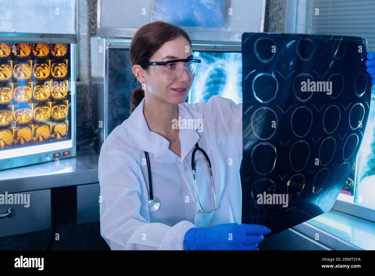Female medical radiologist doctor looking head and brain x-ray film before surgery in lab office at hospital. Healthcare and education. Stock Photo