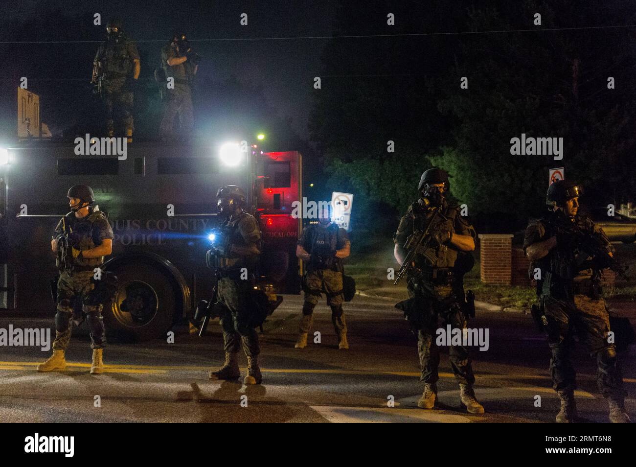 (140819) -- FERGUSON, Aug. 19, 2014 -- Police special units equipped with military gear stand guard during the protests against police killing of Michael Brown in Ferguson, Missouri, the United States, on Aug. 19, 2014. On Aug. 9, 18-year-old African American Michael Brown was shot dead by police in Ferguson, sparking a week-long protest in the town where most of the population is black. )(zhf) US-MISSOURI-FERGUSON-PROTEST ShenxTing PUBLICATIONxNOTxINxCHN   Ferguson Aug 19 2014 Police Special Units Equipped With Military Gear stand Guard during The Protest against Police Killing of Michael Bro Stock Photo