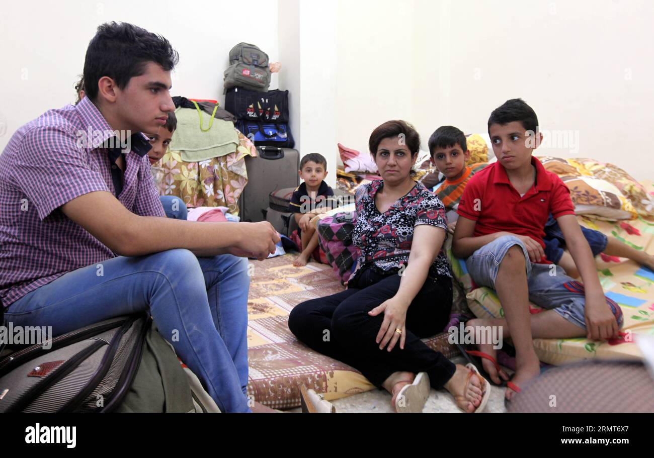 An Iraqi Christian family, who fled the violence to Jordan, stands at Dar Al Salam Association in Amman, Jordan on Aug. 19, 2014. Iraqi Christian families sought sanctuary in Jordan after fleeing towns and villages to escape the advance of Islamic State militants.) JORDAN-AMMAN-IRAQI CHRISTIAN MohammadxAbuxGhosh PUBLICATIONxNOTxINxCHN   to Iraqi Christian Family Who  The Violence to Jordan stands AT dar Al Salam Association in Amman Jordan ON Aug 19 2014 Iraqi Christian families sought Sanctuary in Jordan After fleeing Towns and Villages to Escape The Advance of Islamic State militant Jordan A Stock Photo
