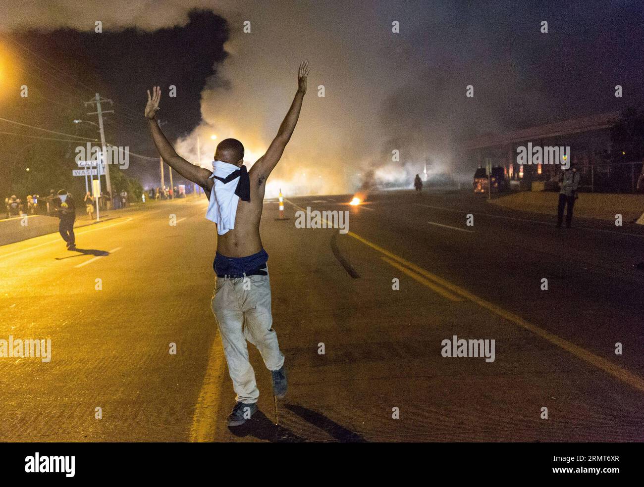 140819 -- FERGUSON, Aug. 19, 2014 -- A protestor walks away with his hands up from teargas smoke during protests against police killing of Michael Brown in Ferguson, Missouri, the United States.18-year-old African American Michael Brown was shot dead by police in Ferguson, sparking continuous protests in the town where most of the population is black.  US-MISSOURI-FERGUSON-PROTEST-CLASH ShenxTing PUBLICATIONxNOTxINxCHN Stock Photo