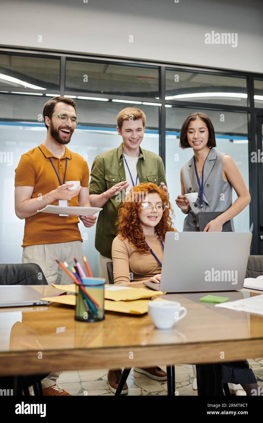 cheerful business team smiling during video conference on laptop in coworking office Stock Photo