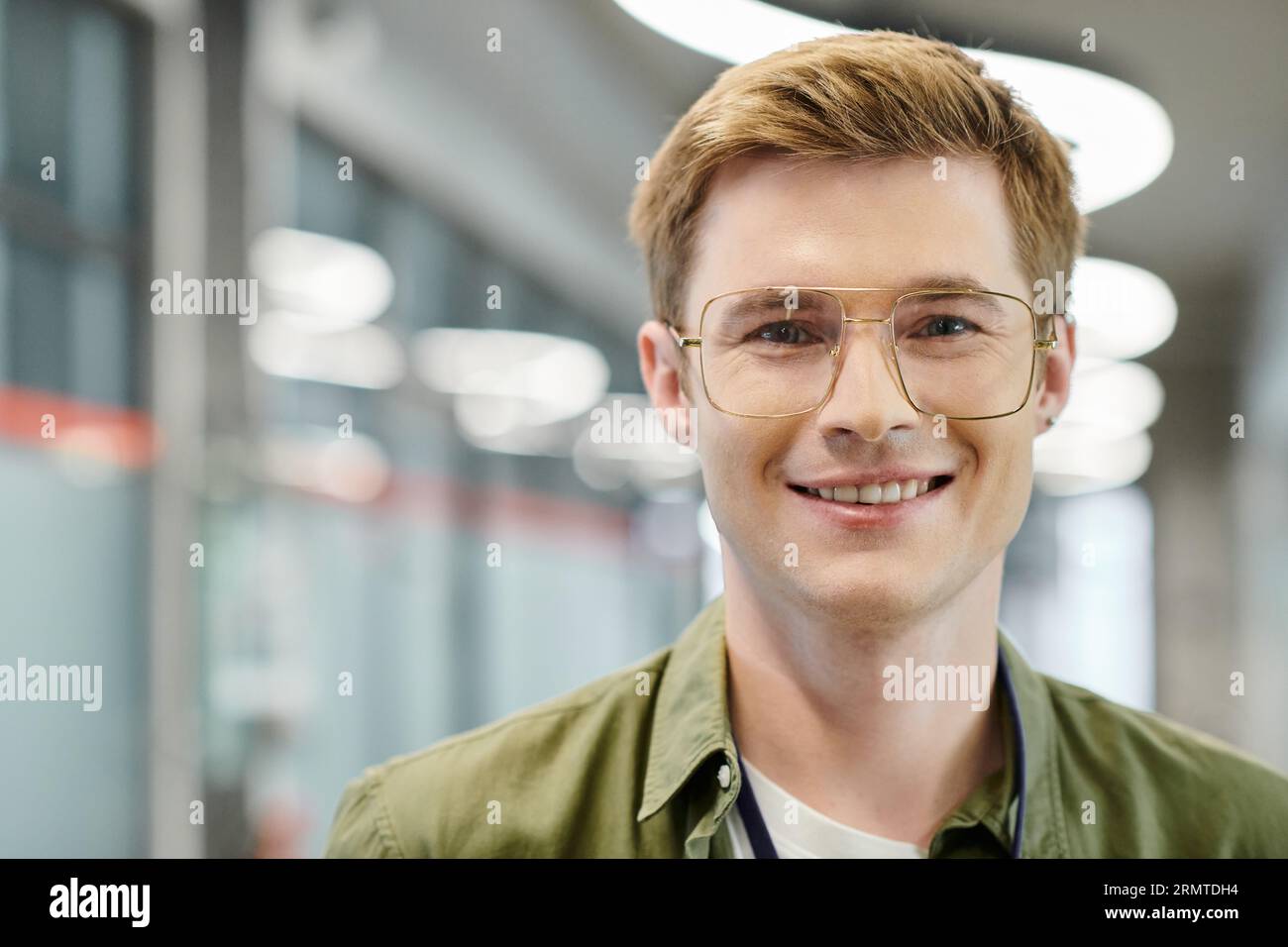 portrait of pleased businessman in eyeglasses looking at camera, successful entrepreneurship Stock Photo
