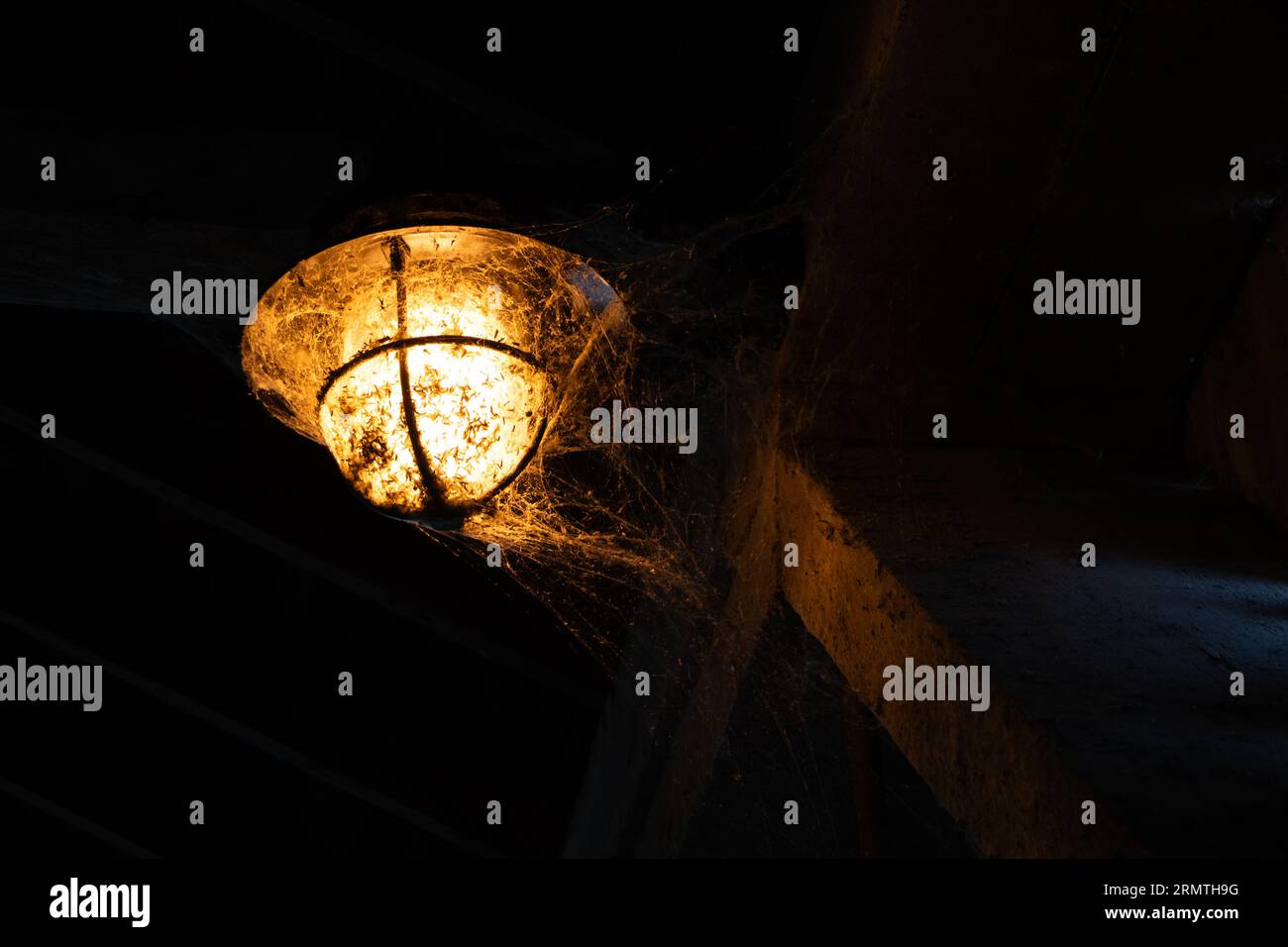 Street lamp with cobwebs inside a covered bridge Stock Photo