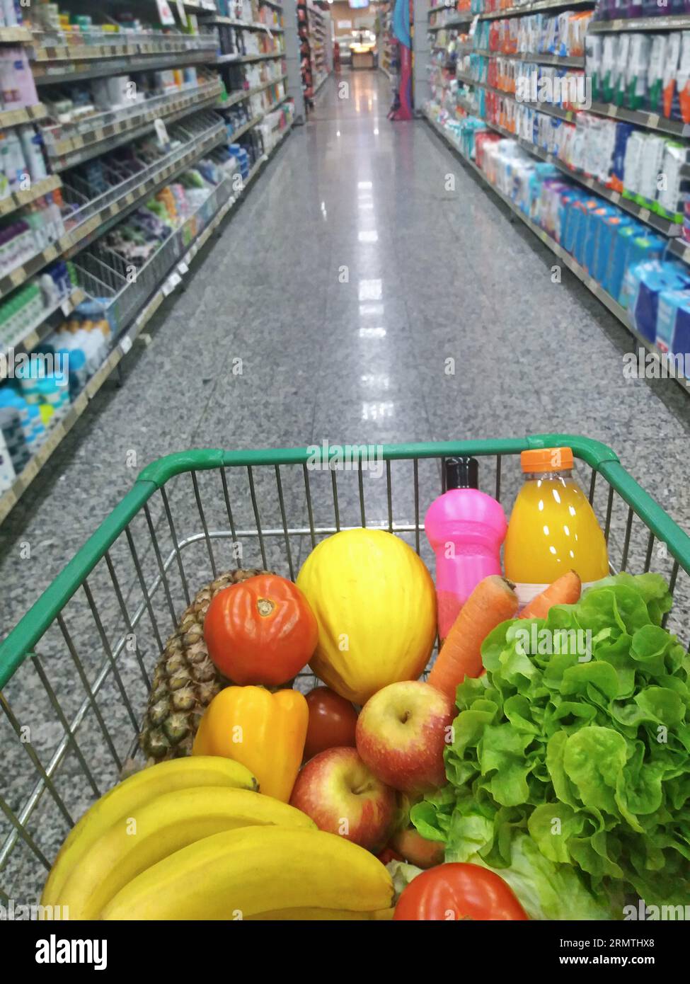 Products inside a cart in a supermarket where aisles appears with
