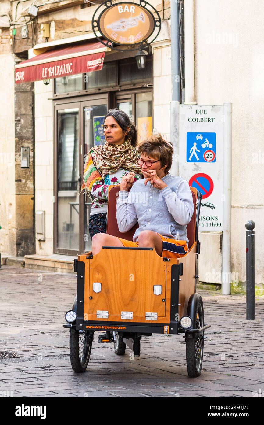 Mother and partially disabled child riding an Eco-Triporteur electric assisted cargo bike - Tours, Indre-et-Loire (37), France. Stock Photo