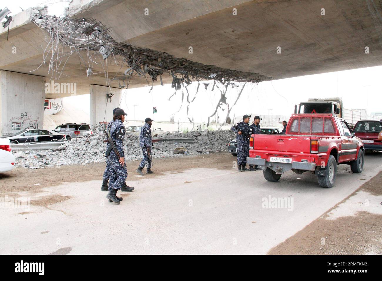 TRIPOLI, Sept. 9 -- Policemen inspect cars under a damaged bridge in Tripoli, Libya, on Sept. 9, 2014. A number of checkpoints were set up on some key roads in Tripoli by local policemen to maintain the security in the capital city. Since July, Tripoli has been seeing bloody clashes between armed Islamist groups and pro-secular militias. ) LIBYA-TRIPOLI-SECURITY HamzaxTurkia PUBLICATIONxNOTxINxCHN   Tripoli Sept 9 Policemen inspect Cars Under a damaged Bridge in Tripoli Libya ON Sept 9 2014 a Number of Checkpoints Were Set up ON Some Key Roads in Tripoli by Local Policemen to maintain The Secu Stock Photo