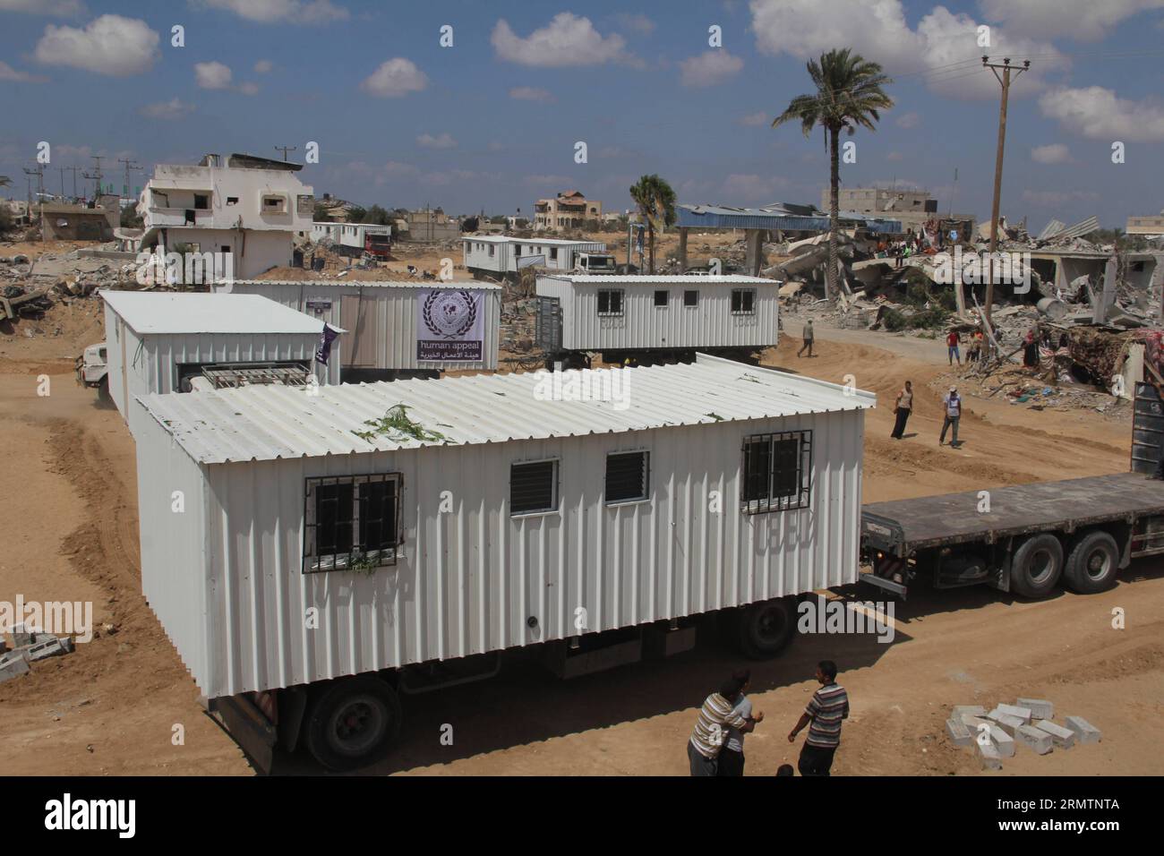Mobile homes donated by an United Arab Emirates association are delivered to Palestinian families whose houses were destroyed by bombings during the Israeli offensive on the Gaza Strip, in Khuzaa neighborhood in the southern Gaza Strip City of Khan Younis, on Sept. 13, 2014. Some 60,000 homes were impacted during the 50-day Israeli offensive, a third of which became uninhabitable. ) MIDEAST-GAZA-MOBILE HOMES KhaledxOmar PUBLICATIONxNOTxINxCHN   Mobile Homes Donated by to United Arab Emirates Association are delivered to PALESTINIAN families whose Houses Were destroyed by bombings during The Is Stock Photo