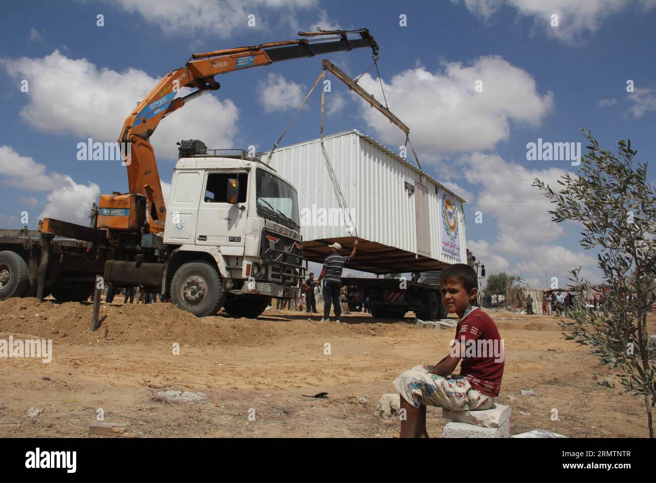 Mobile homes donated by an United Arab Emirates association are delivered to Palestinian families whose houses were destroyed by bombings during the Israeli offensive on the Gaza Strip, in Khuzaa neighborhood in the southern Gaza Strip City of Khan Younis, on Sept. 13, 2014. Some 60,000 homes were impacted during the 50-day Israeli offensive, a third of which became uninhabitable. ) MIDEAST-GAZA-MOBILE HOMES KhaledxOmar PUBLICATIONxNOTxINxCHN   Mobile Homes Donated by to United Arab Emirates Association are delivered to PALESTINIAN families whose Houses Were destroyed by bombings during The Is Stock Photo