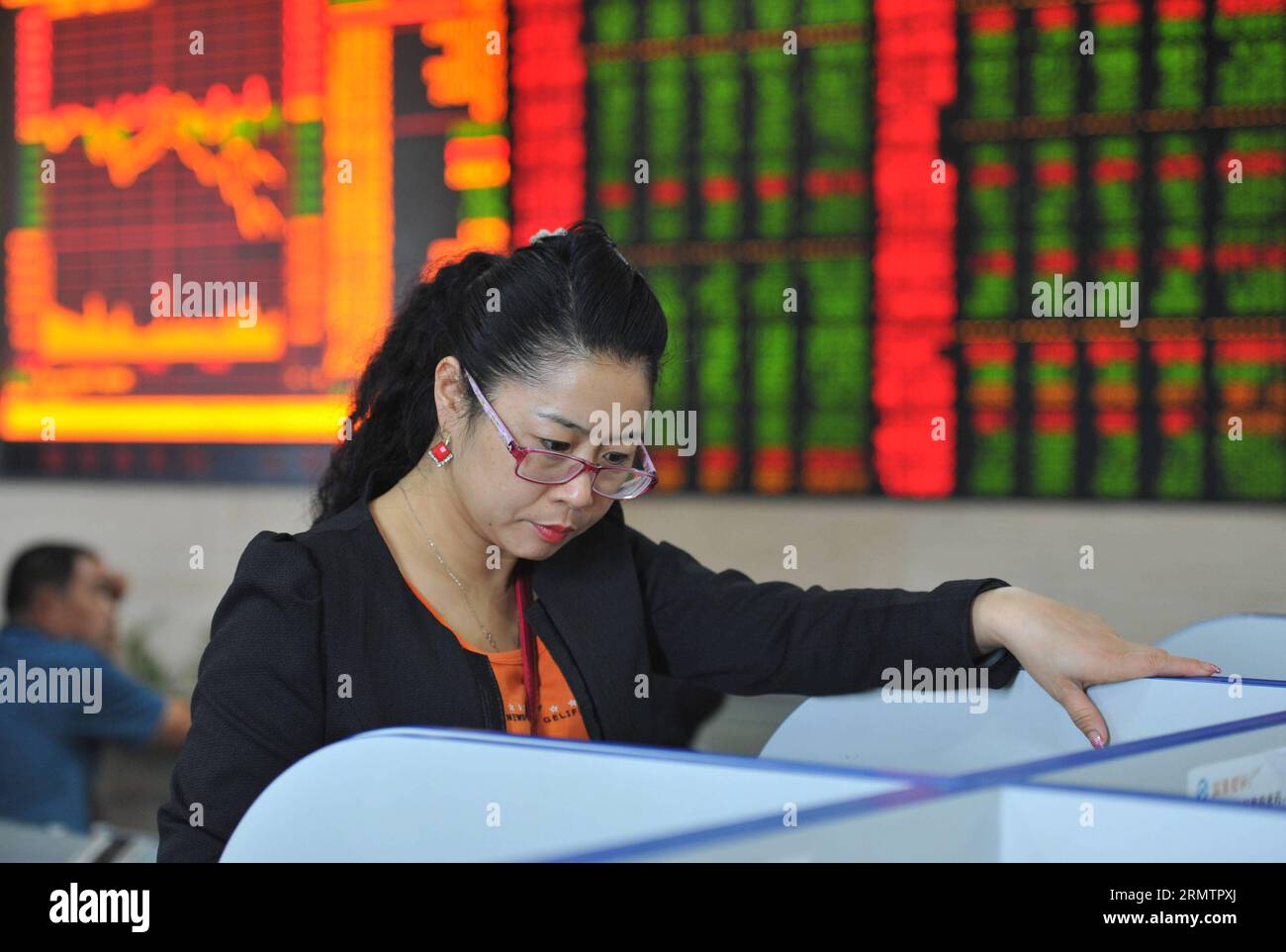 An investor reads stock information at a trading hall of a securities firm in Fuyang City, east China s Anhui Province, Sept. 16, 2014. Chinese shares closed lower on Tuesday, with the benchmark Shanghai Composite Index down 1.82 percent to finish at 2,296.55 points, owing to the plunge of growth enterprises. The smaller Shenzhen Component Index lost 191.57 points, or 2.36 percent, to close at 7,921.07 points. ) (ry) CHINA-STOCK-DROP (CN) LuxQijian PUBLICATIONxNOTxINxCHN   to Investor reads Stick Information AT a Trading Hall of a Securities Firm in Fuyang City East China S Anhui Province Sept Stock Photo