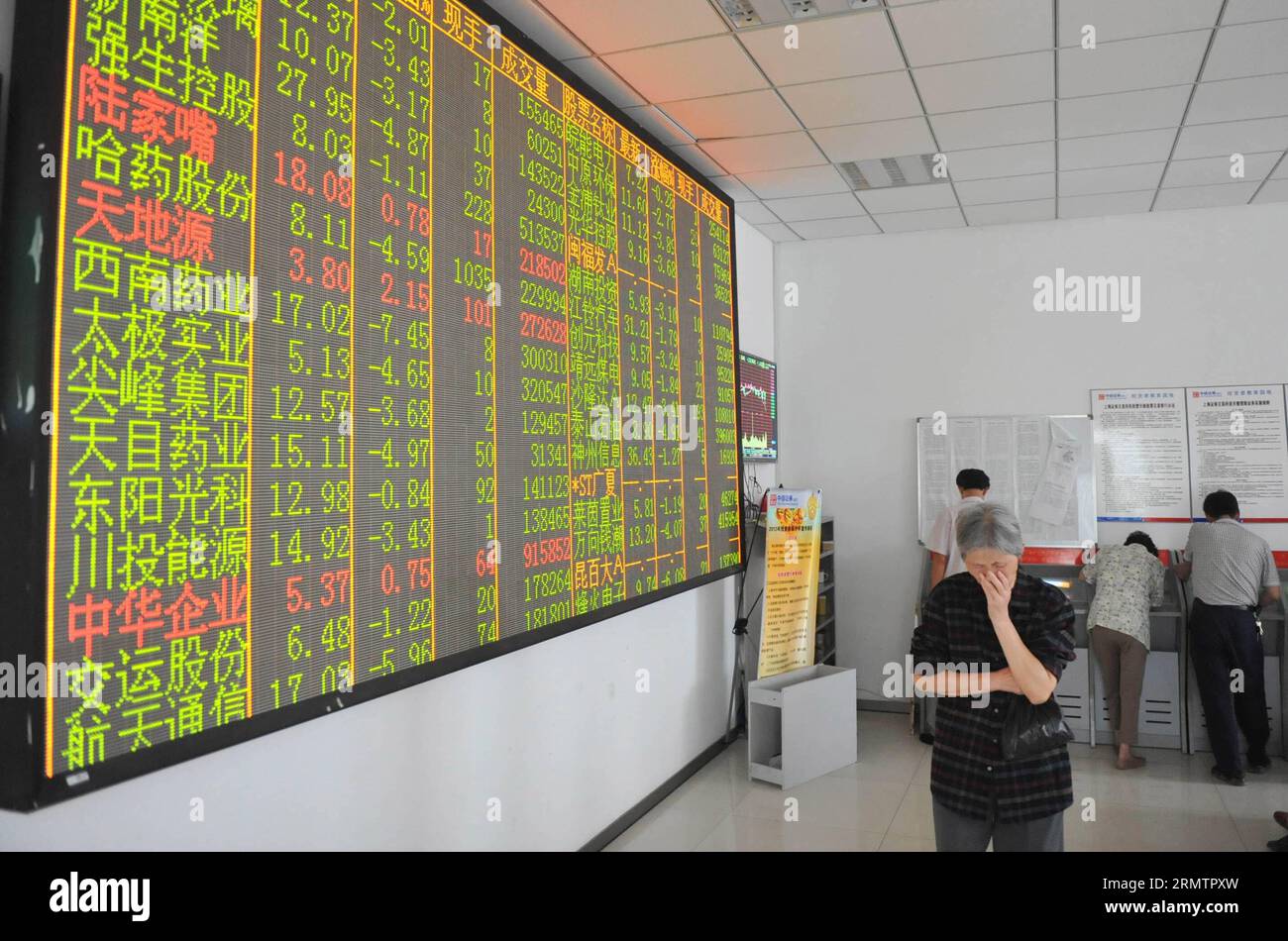 An investor walks past a screen showing stock information at a trading hall of a securities firm in Hangzhou, capital of east China s Zhejiang Province, Sept. 16, 2014. Chinese shares closed lower on Tuesday, with the benchmark Shanghai Composite Index down 1.82 percent to finish at 2,296.55 points, owing to the plunge of growth enterprises. The smaller Shenzhen Component Index lost 191.57 points, or 2.36 percent, to close at 7,921.07 points. () (ry) CHINA-STOCK-DROP (CN) Xinhua PUBLICATIONxNOTxINxCHN   to Investor Walks Past a Screen showing Stick Information AT a Trading Hall of a Securities Stock Photo