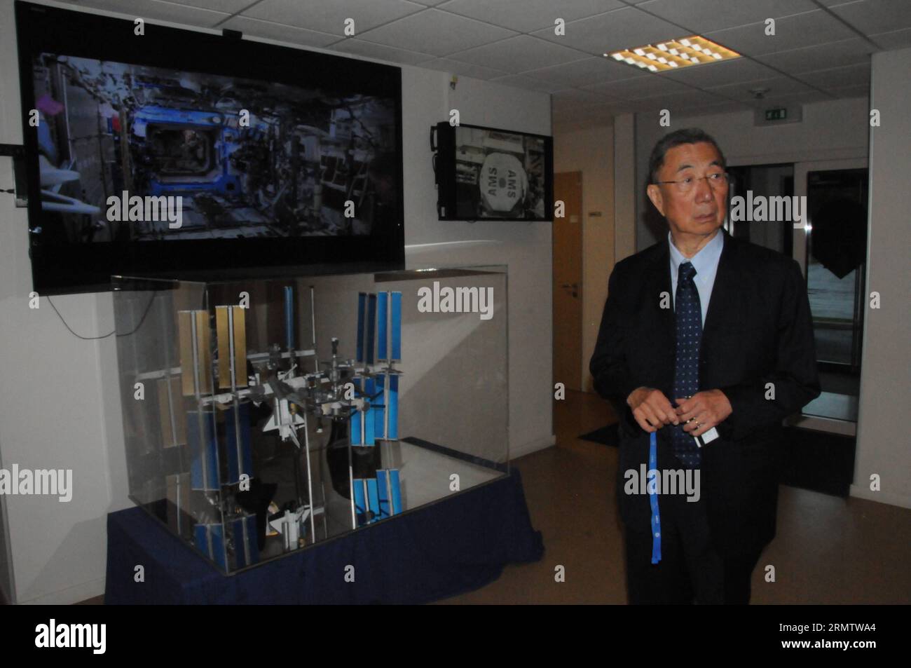 (140920) -- GENEVA, Sept. 18, 2014 -- Nobel laureate Samuel Ting stands in front of the monitor of the International Space Station (ISS) in the laboratory in Geneva, Switzerland, Sept. 18, 2014. The Alpha Magnetic Spectrometer (AMS) team led by Ting announced on Thursday new results in the search for dark matter, shedding more light on the dark matter existence. Cosmic rays are charged high-energy particles that permeate space. The AMS, a particle physics detector installed on the ISS, is designed to study them before they have a chance to interact with the Earth s atmosphere. ) (zjy) SWITZERL Stock Photo