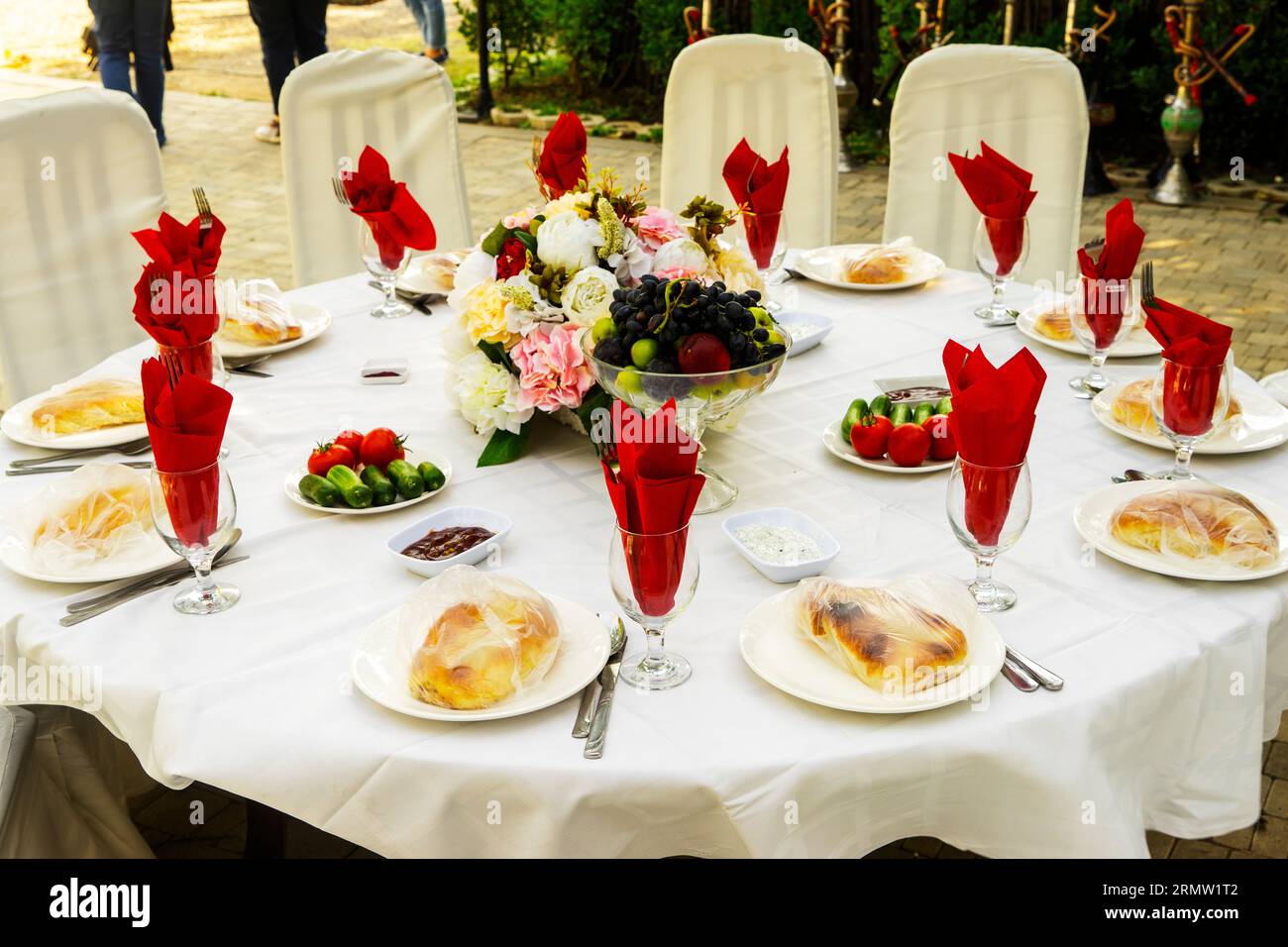 Elegant banquet tables prepared for a conference or a party and covered with a white tablecloth and decorated with flowers for guests Stock Photo