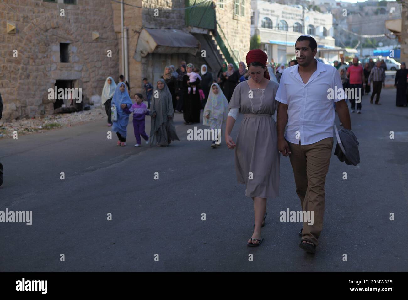 (141004) -- HEBRON, Oct. 4, 2014 -- Jewish worshipers walk near the al-Ibrahimi mosque, a religious site to Muslims, in the West Bank City of Hebron on Oct. 4, 2014. The Jewish fast of Yom Kippur is coinciding with the Muslim festival of Eid al-Adha for the first time in three decades. The concurrence of the holy days has not occurred for 33 years because the two faiths use different lunar calendars. ) MIDEAST-HEBRON-JEWISH-MUSLIMS MamounxWazwaz PUBLICATIONxNOTxINxCHN   Hebron OCT 4 2014 Jewish Worshiper Walk Near The Al Ibrahimi Mosque a Religious Site to Muslims in The WEST Bank City of Hebr Stock Photo