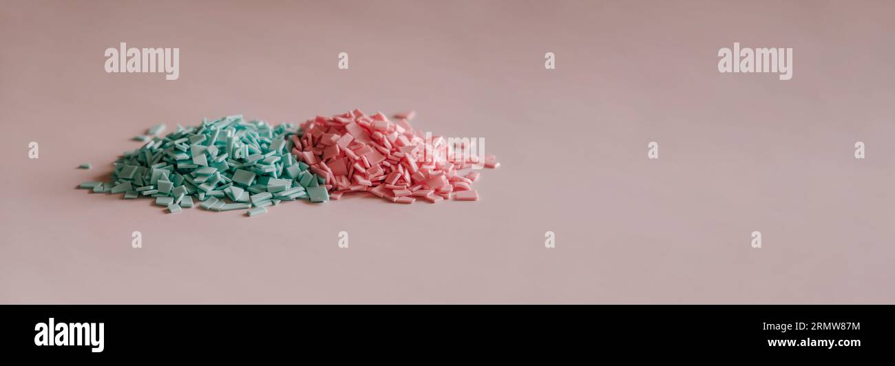 A pile of plastics - small pieces of hard plastic, pink and blue color, intended for further processing Stock Photo