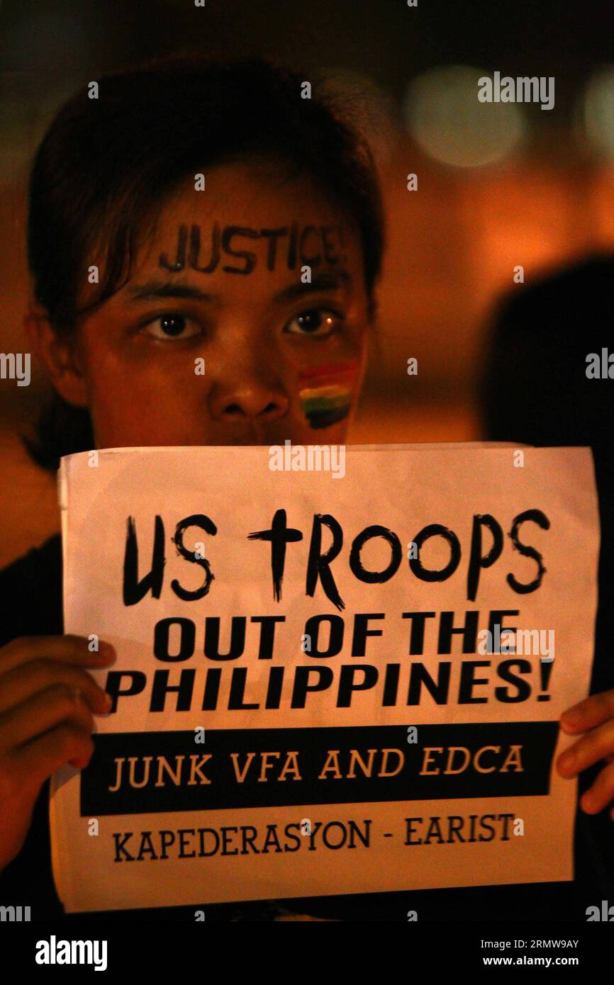(141014) -- MANILA, Oct. 14, 2014 -- An activist holds a placard calling for the junking of the Enhanced Defense Cooperation Agreement (EDCA) during a candlelighting rally in Manila, Philippines on Oct. 14, 2014. The Philippine government on Tuesday vowed justice for a Filipino transgender who was found dead in a hotel in Olongapo City in northern Philippines. A U.S. Marine, identified as Private First Class Joseph Scott Pemberton, was tagged as a possible suspect in the murder of Jeffrey Laude. ) (cy) Authorized by ytfs PHILIPPINES-MANILA-CANDLELIGHTING RALLY RouellexUmali PUBLICATIONxNOTxINx Stock Photo