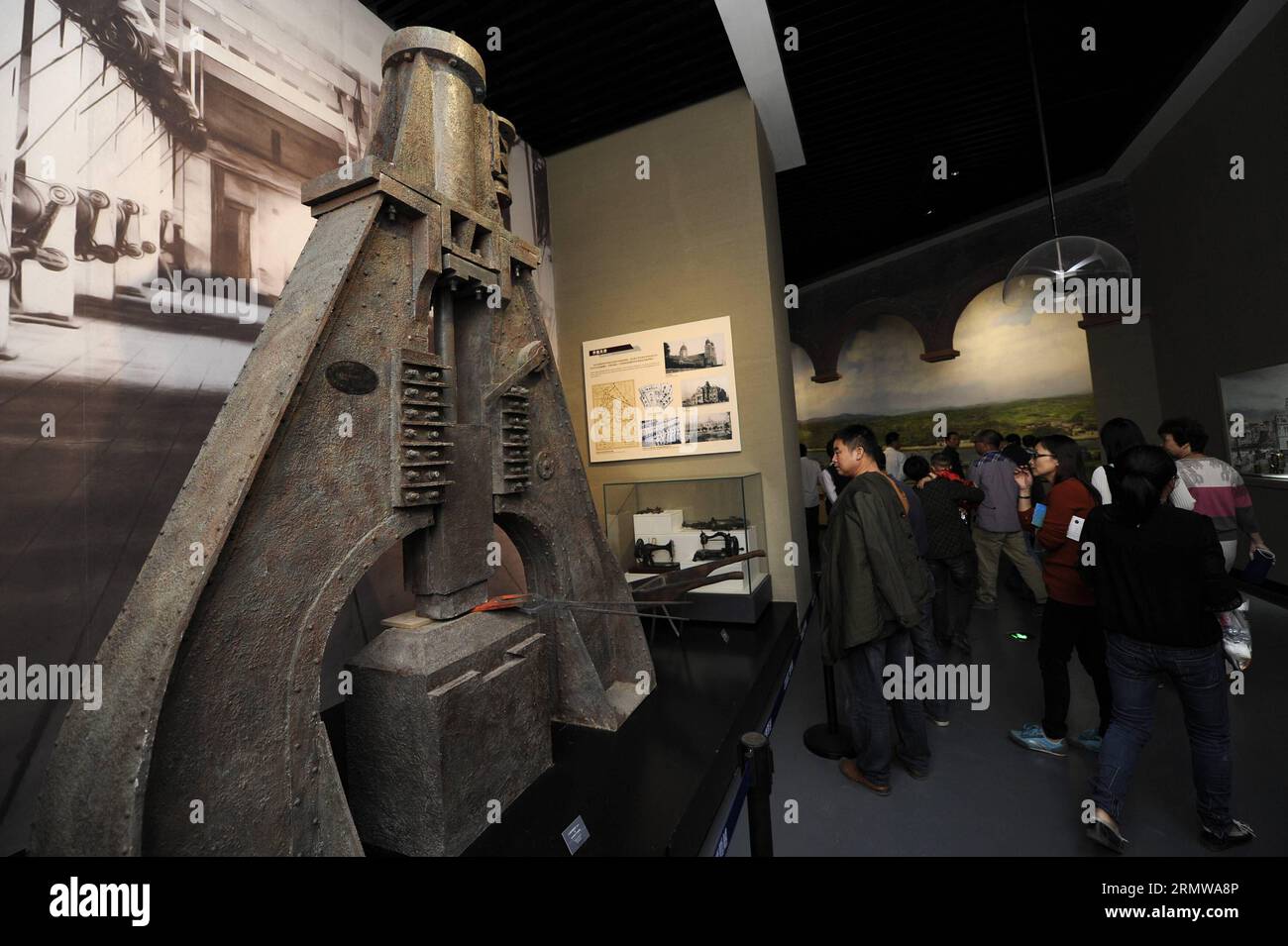 (141016) -- NINGBO, Oct. 16, 2014 -- A visitor looks at a replication of a forging machine at the China Port Museum in Ningbo, east China s Zhejiang Province, Oct. 16, 2014. China Port Museum, also the National Underwater Cultural Heritage Protection Center Ningbo Base, opened on Thursday. ) (mp) CHINA-ZHEJIANG-NINGBO-PORT MUSEUM-OPENING (CN) JuxHuanzong PUBLICATIONxNOTxINxCHN   Ningbo OCT 16 2014 a Visitor Looks AT a replication of a forging Machine AT The China Port Museum in Ningbo East China S Zhejiang Province OCT 16 2014 China Port Museum Thus The National UNDERWATER Cultural Heritage Pr Stock Photo