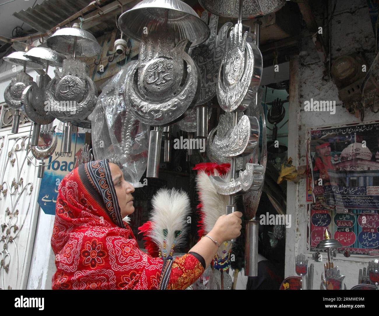 A Pakistani Shiite Muslim woman buys goods at a special decoration shop