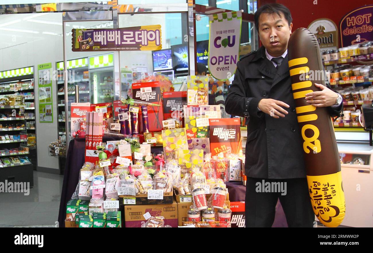 A sales person holds a pepero shaped balloon in front of a grocery store in Seoul, South Korea, Nov. 11, 2014. Pepero Day is celebrated annually on Nov. 11 in South Korea, with stores selling pepero chocolate sticks and single people trying to find their Mr or Mrs Rights. ) SOUTH KOREA-PEPERO DAY-SALE YaoxQilin PUBLICATIONxNOTxINxCHN   a Sales Person holds a  Shaped Balloon in Front of a Grocery Store in Seoul South Korea Nov 11 2014  Day IS celebrated annually ON Nov 11 in South Korea With Stores Selling  Chocolate Sticks and Single Celebrities trying to find their Mr or Mrs Rights South Kore Stock Photo