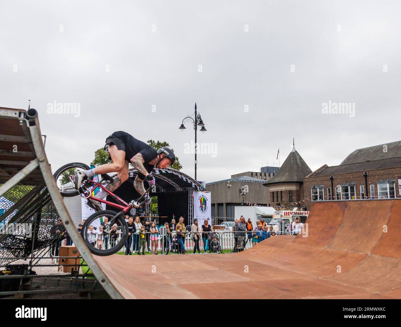 A youth on a BMX bike performing aerial stunts in a BMX display in the