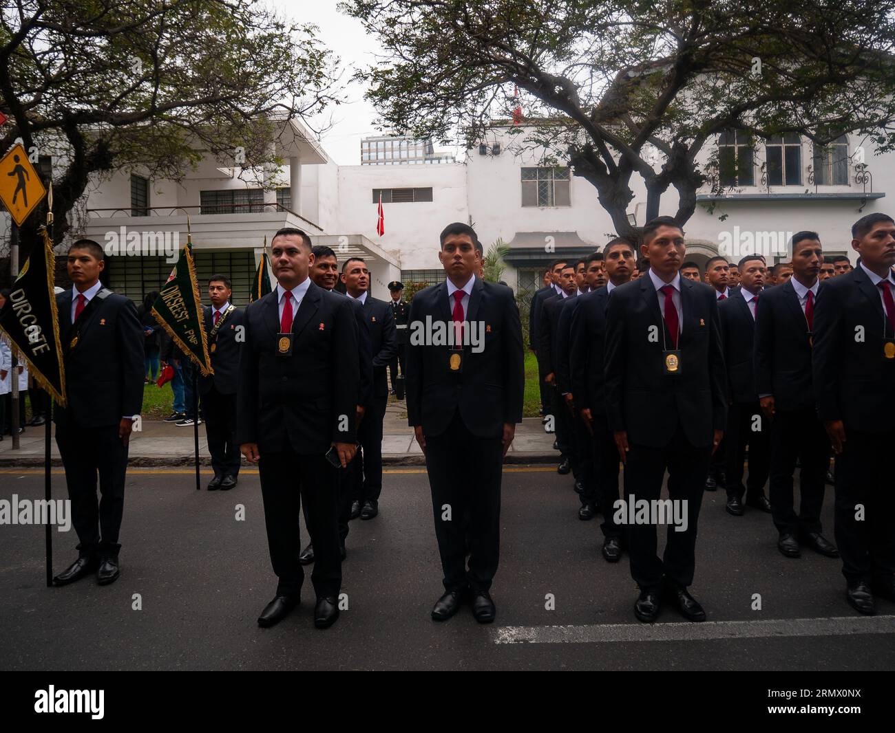 Lima, Peru - July 29 2023: Young Peruvian Men Dressed in Dark Suits and Red Ties Wear a Medal of Honor Hanging from their Necks at the Independence Da Stock Photo