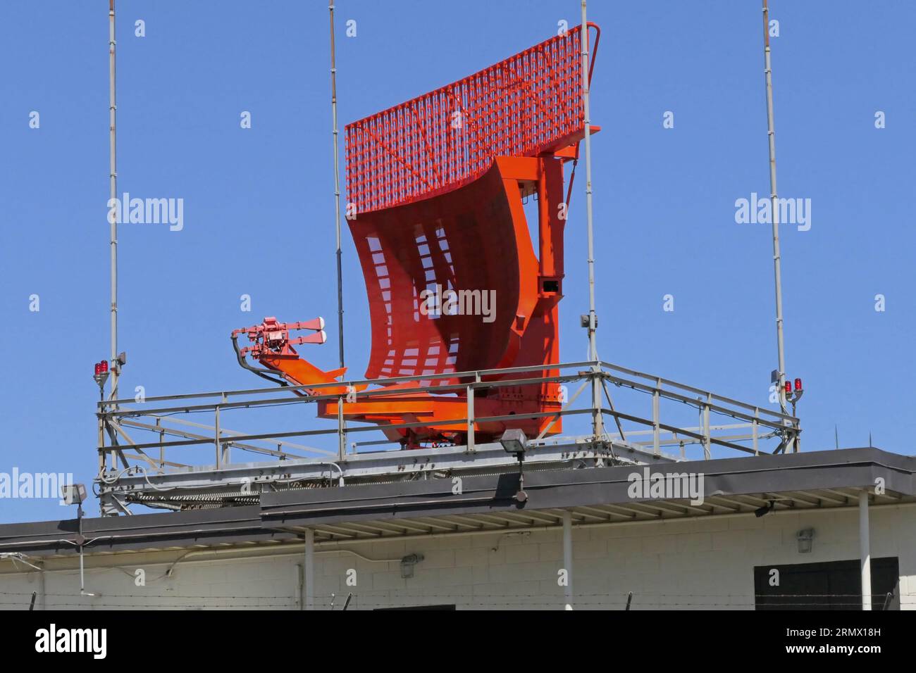 A radar antenna dish near a large, international airport is shown
