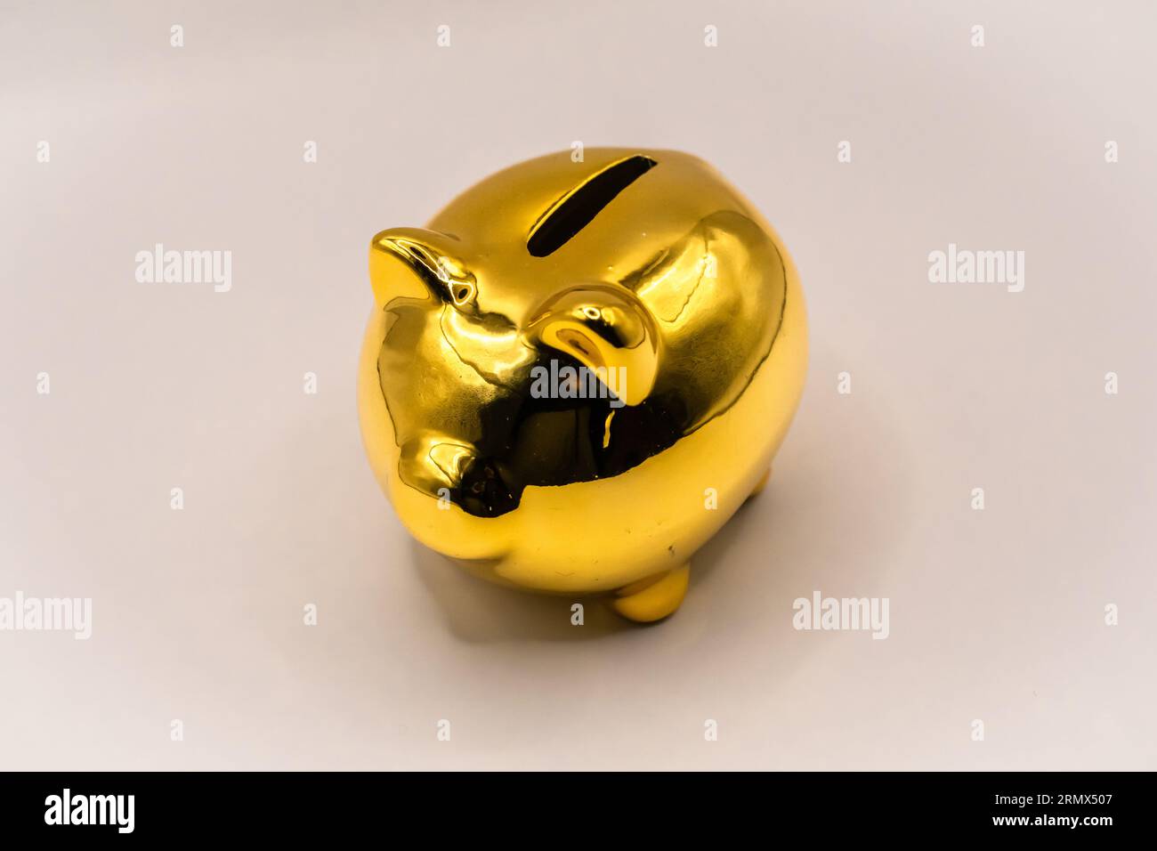 golden piggy bank on white background Stock Photo - Alamy