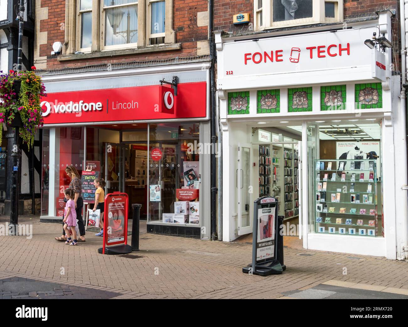 Two mobile phone shops next door, High Street, Lincoln City, Lincolnshire, England, UK Stock Photo