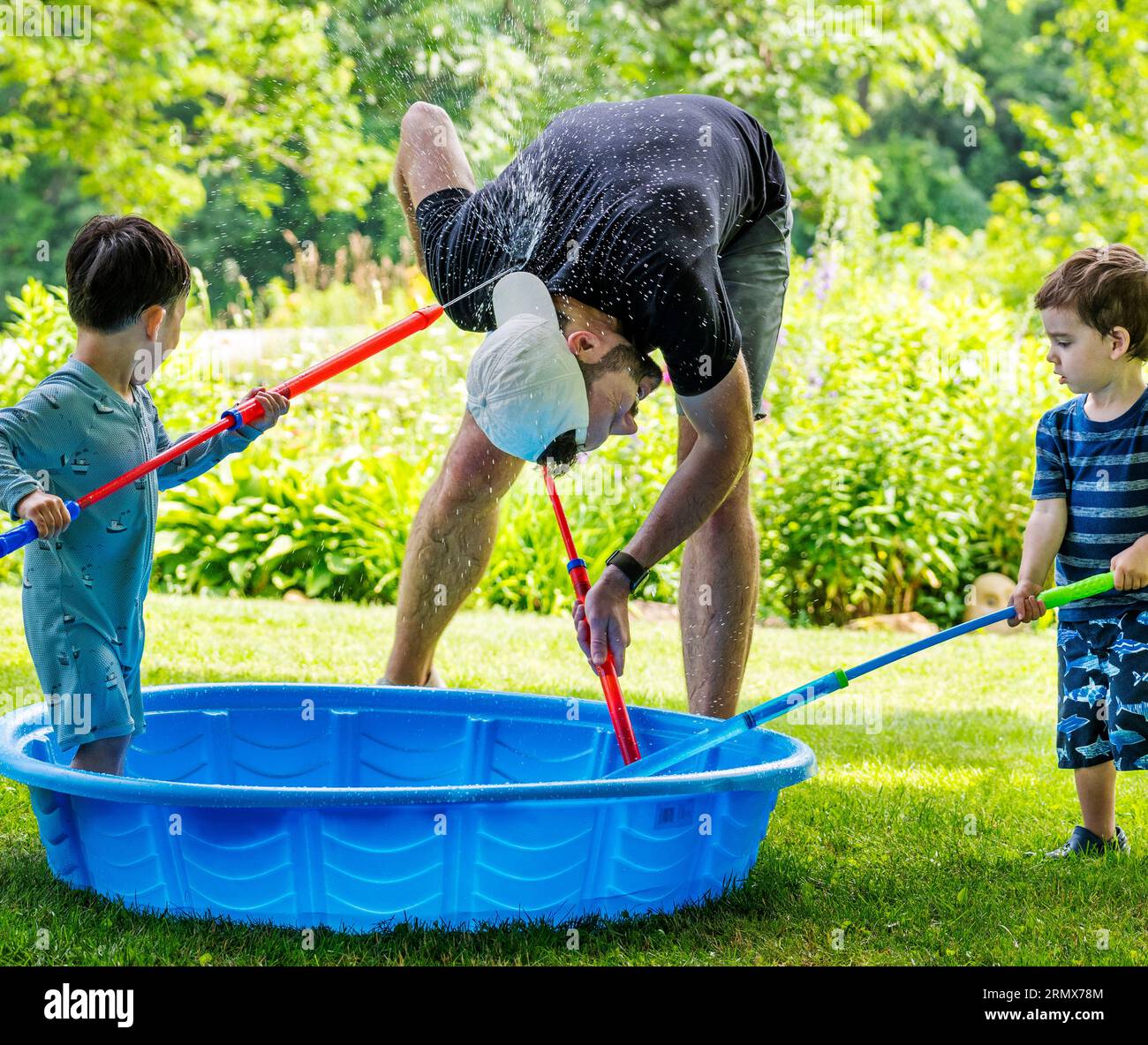 Father and young son playing with water toys on a hot summer day Stock Photo