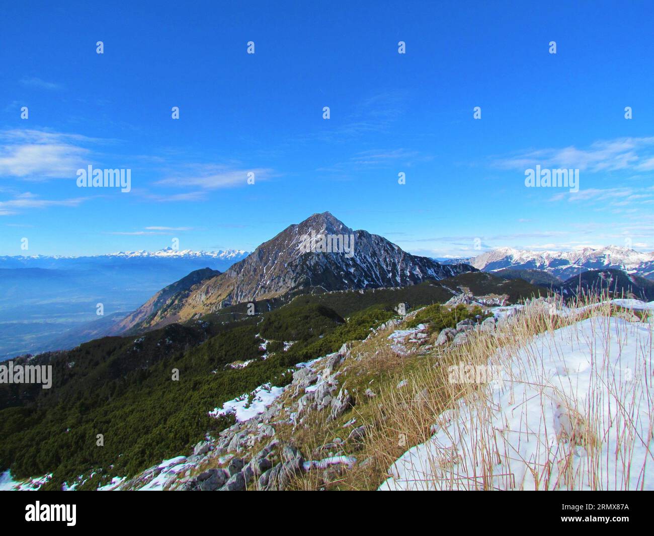 Scenic view of mountain Storzic in Kamnik-Savinja alps in Gorenjska region of Slovenia with creeping pine covered alpine landscape in front and the Ju Stock Photo
