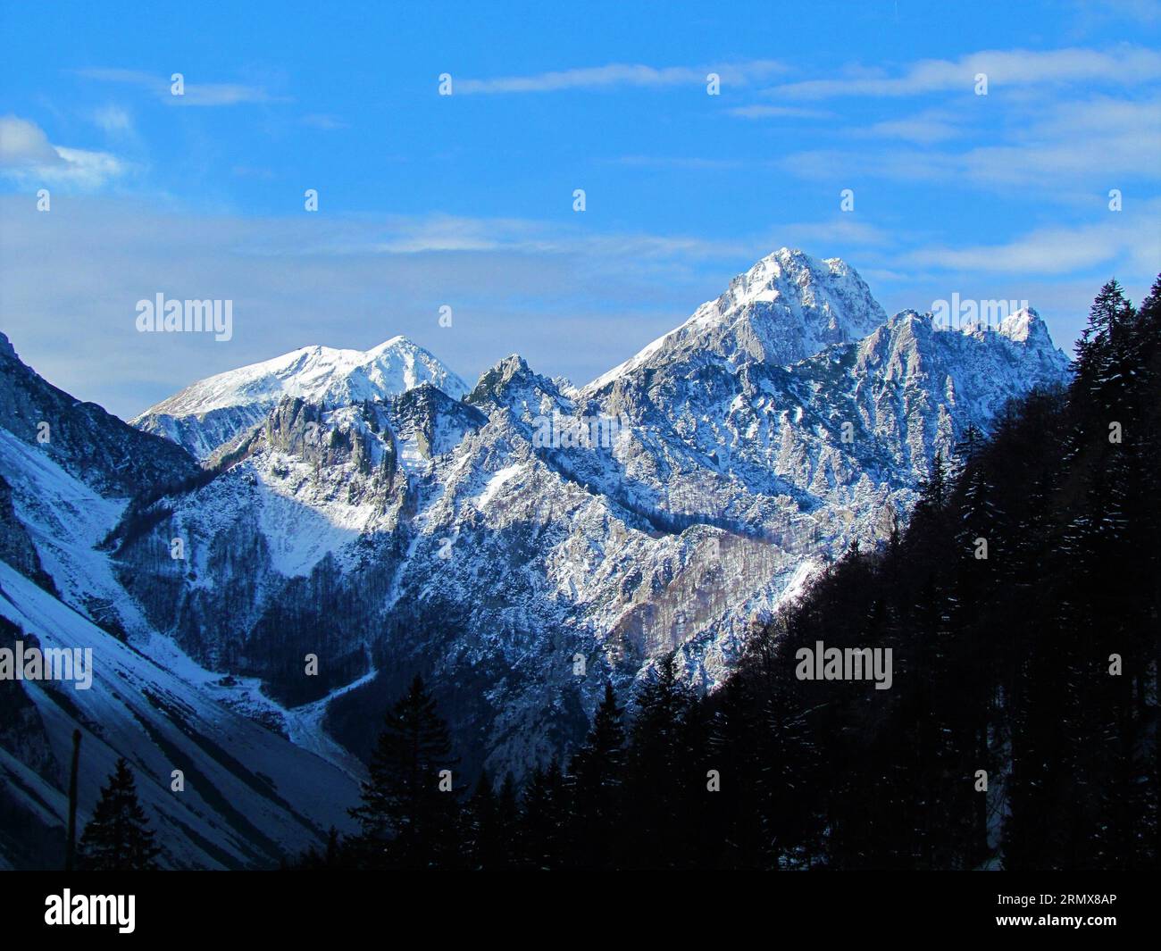 Scenic view of mountain Vrtaca with mountain Stol in Karavanke mountains in  Gorenjska region of Slovenia the back lit by the sun in winter with snow c  Stock Photo - Alamy