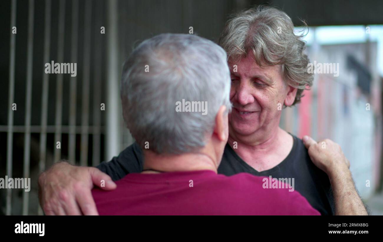 Heart-warming embrace between two senior friends in authentic loving ...