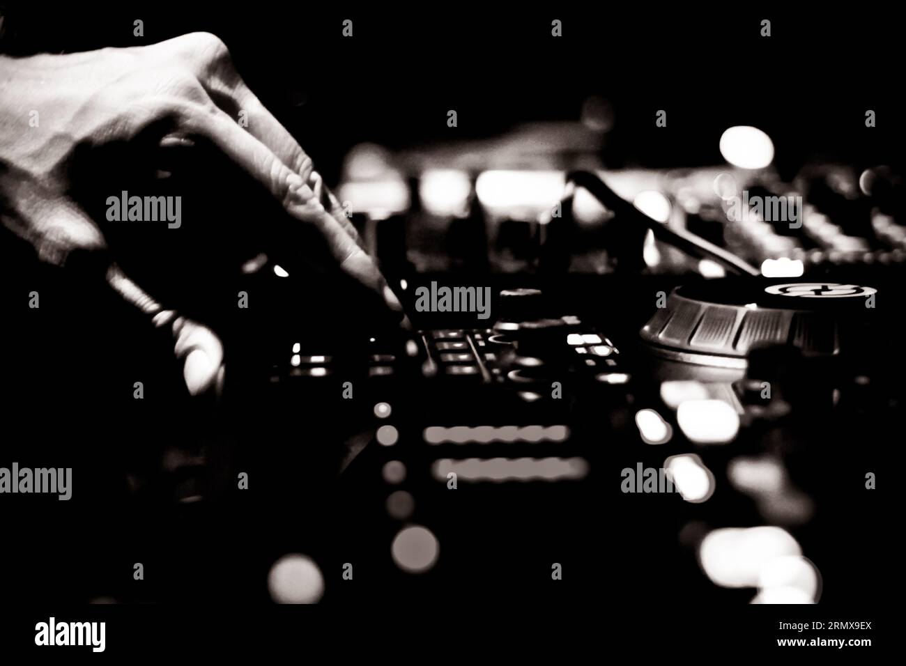 Club DJ adjusting controls on mixer. Stock Photo