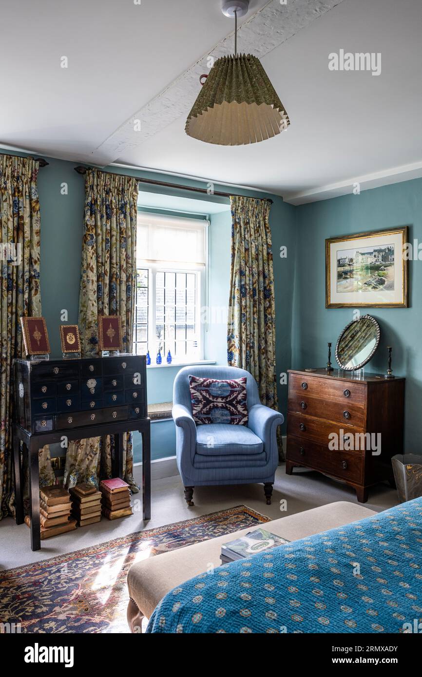 Blue armchair in window with antique drawers in 18th century Georgian home, Northamptonshire, UK Stock Photo