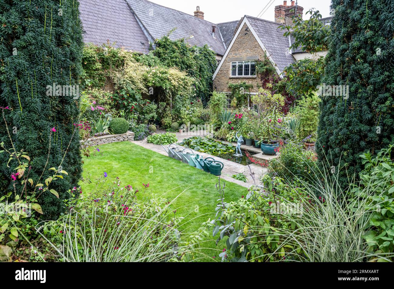 Watering cans and lawn in secluded garden of 18th century