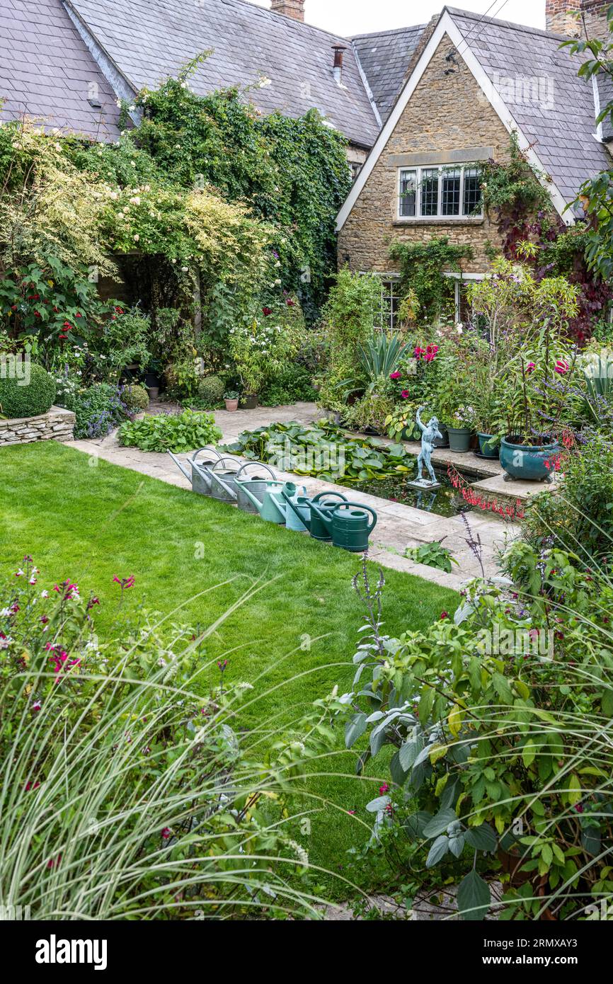 Watering cans and lawn in secluded garden of 18th century