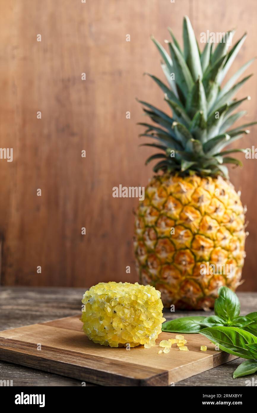 A fresh pineapple and goat cheese with pineapple pieces and basil close-up Stock Photo