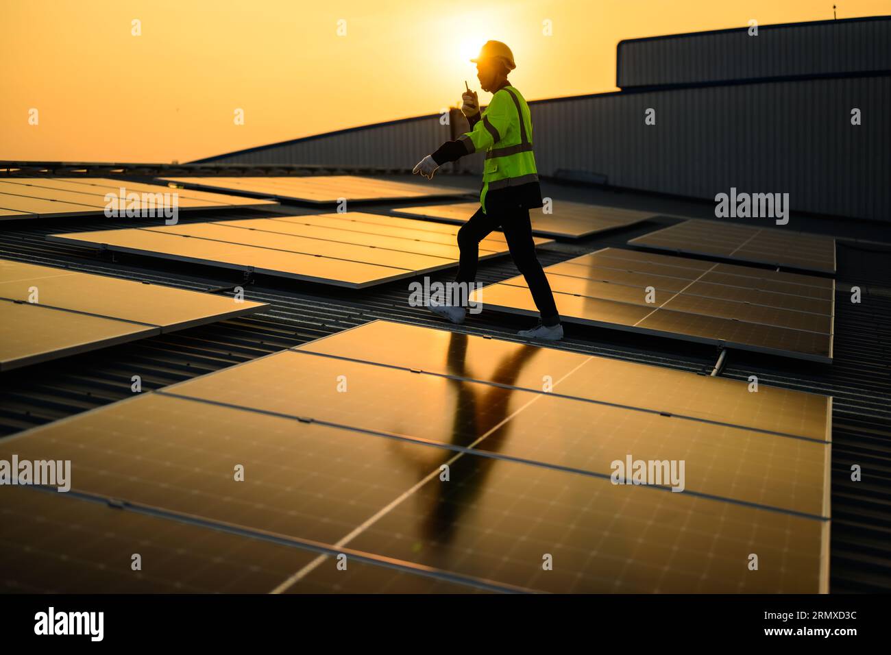 Engineer working at solar cell farm power plant with sunset in evening ...